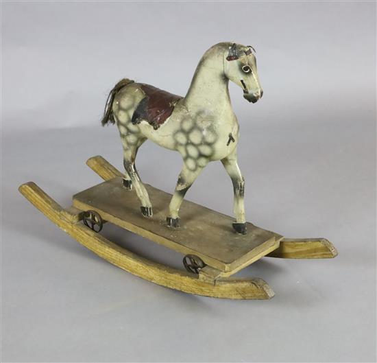 A rare Victorian carved and painted wood dapple grey rocking horse, W.31in. H.22in.